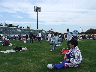 芝生には、準備運動をする人たちや、付き添いで来た子供達も